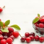 Friss aszalt áfonya és bogyók egy tálban és körülötte