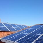 Napelemek egy otthon tetején, a világos égen.