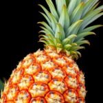 Friss ananász egy fekete háttér előtt, a trópusi gyümölcs szépsége.